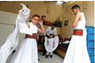  ??  ?? Sufi Dervish dancers of the Kharrat family don their costumes at their home.