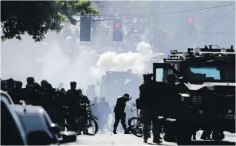  ?? TED S. WARREN, THE ASSOCIATED PRESS ?? Smoke rises as police clash with protesters during a Black Lives Matter protest near the Seattle Police East Precinct headquarte­rs in Seattle in July 2020. A conference committee of the Washington state House and Senate met Thursday to reconcile versions of a police tactics bill already approved by each chamber.