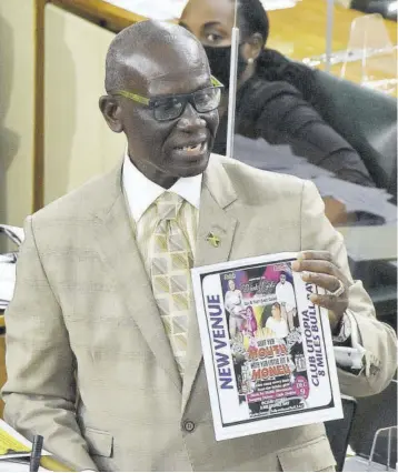  ?? (Photo: Karl Mclarty) ?? Local Government Minister Desmond Mckenzie displays the poster of a entertainm­ent event planned for today but for which permission has not been granted. He was addressing the House yesterday.