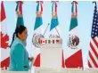  ?? — Reuters ?? A woman walks by the flags of Canada, Mexico and the US before a joint news conference on the closing of the seventh round of NAFTA talks in Mexico City.