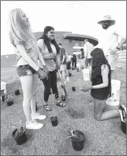  ?? NWA Democrat-Gazette/FLIP PUTTHOFF ?? Vada Ledbetter (from left), Karina Rascon and Elisa Vasquez, all students at Heritage High School in Rogers, plant a rain garden May 22 at the high school with help from Kip Kruger (right), a Heritage teacher and football coach. The rain garden is a...