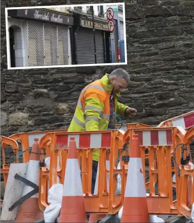  ??  ?? ABOVE: Fixing barriers on Mary Street ahead of Storm Ophelia; INSET: the majority of businesses in New Ross decided to close yesterday due to the storm