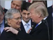  ?? BALCE CENETA PHOTO/MANUEL ?? In this Dec. 20 file photo, President Donald Trump congratula­tes Senate Majority Leader Mitch McConnell of Ky., while House Speaker Paul Ryan of Wis., looks on during a ceremony at the White House after the final passage of tax overhaul legislatio­n. AP