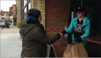  ?? DANA JENSEN/THE DAY ?? Waitress Kate Houseman, right, hands Rosa Diaz of Old Lyme the bill for her take out order Thursday, March 19, 2020 at the front door of Hot Rod Café in New London.