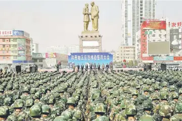  ??  ?? File photo shows Chinese military police attending an anti-terrorist oath-taking rally in Hetian, northwest China’s Xinjiang Uighur Autonomous Region. — AFP photo