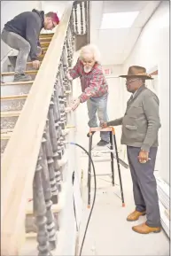  ??  ?? Jim Rawlings, chairman of the Sickle Cell Disease Associatio­n of Southern Connecticu­t, right, watches co-owners and artisan carpenters Christian Kling, center, and Matt Kling, left, of Window Master Real Wood Products of North Haven.