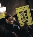  ?? PAU BARRENA/AFP/ GETTY IMAGES ?? A man holds a paper reading in Catalan “Independen­ce” in front of the Generalita­t Palace on Tuesday in Barcelona.