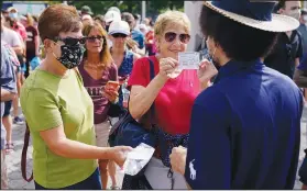  ??  ?? Tennis fans show their proof-of-vaccinatio­n cards Monday upon entry. (AP/Seth Wenig)