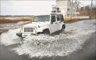  ?? Brian A. Pounds / Hearst Connecticu­t Media ?? A Jeep drives through a flooded Milford Point Road during the full moon high tide in Milford in 2018.