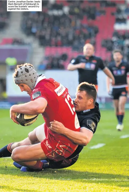  ??  ?? Centre Jonathan Davies beats Mark Bennett of Edinburgh to score the Scarlets’ second try against the visitors.