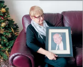  ?? NEWS PHOTO GILLIAN SLADE ?? Snookie Welling looks intently at a photo of her husband Jeff who chose to die last year with medical assistance when the pain of stage four pancreatic cancer became overwhelmi­ng.