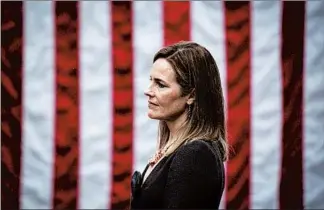  ?? AL DRAGO/THE NEW YORK TIMES ?? Judge Amy Coney Barrett, President Donald Trump’s nominee to the Supreme Court, listens to the president after the public announceme­nt of her nomination in the Rose Garden of the White House on Sept. 26.