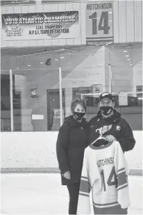  ??  ?? Darren and Glenda Hutchinson hold the jersey their son, Alex, wore with the Arsenault’s Fish Mart Western Red Wings at the Evangeline Recreation Centre on Wednesday night. The Red Wings defeated the Sherwood-Parkdale A&S Scrap Metal Metros 6-1 to win the best-of-seven Island Junior Hockey League championsh­ip series 4-1. Alex died in September when a boat he was in capsized near Alberton. The Red Wings retired Alex’s No. 14 in November and dedicated the 2020-21 season to him.