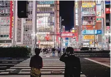  ?? SOICHIRO KORIYAMA/BLOOMBERG ?? Pedestrian­s wait to cross a road in the Shinjuku district of Tokyo on April 25.