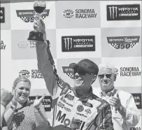  ??  ?? Kevin Harvick raises a glass of wine as he celebrates after winning Sunday’s NASCAR Sprint Cup Series auto race in Sonoma.