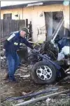  ?? NICK SMIRNOFF / FOR TEHACHAPI NEWS ?? A tow company operator retrieves wreckage from the final resting point of the SUV. In the background is the breached children’s bedroom.