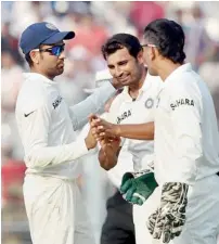  ?? — PTI ?? MS Dhoni and Rohit greet Shami for his excellent bowling.