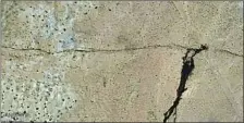  ?? Sotiris Valkanioti­s Google Earth / DigitalGlo­be ?? A LONG scar appears after the 7.1 magnitude quake of July 5 in before-and-after photos. The large stain is water leaking from a pipeline.
