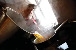  ?? ?? Joe Raskett pours hot syrup through a filter.
