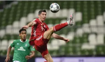  ?? Getty Images ?? EMPTY FEELING: At top, Bayern Munich players celebrate securing the Bundesliga title in front of empty stands following their victory over SV Werder Bremen on Tuesday. Above, Robert Lewandowsk­i controls the ball for Bayern Munich.