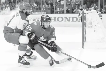  ??  ?? Team Canada’s Brad Marchand, right, is cornered by Team Russia’s Alex Ovechkin in the third period of World Cup of Hockey semifinal action in Toronto on Saturday. Canada will face either Europe or Sweden in a best-of-three final that begins on Tuesday.