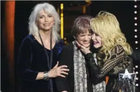  ?? PHOTO BY CHRIS PIZZELLO — INVISION — AP ?? Emmylou Harris, from left, and Linda Ronstadt present Dolly Parton with the MusiCares Person of the Year award on Friday at the Los Angeles Convention Center.