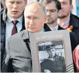  ?? ?? Mr Putin holds an image of his father during the ‘Immortal Regiment’ procession