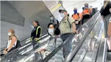  ?? Helen H. Richardson, Denver Post file photo ?? Masked passengers head down the escalator towards the trains at Denver Internatio­nal Airport on July 7.