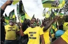  ??  ?? Some of Zuma’s supporters wave ANC flags.
