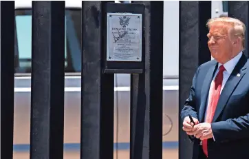  ??  ?? EL PRESIDENTE Donald Trump sonríe luego de autografia­r una sección del muro fronterizo durante un recorrido por San Luis, Arizona