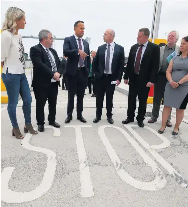  ?? BRIAN LAWLESS/PA WIRE ?? Taoiseach Leo Varadkar (third left) and European Affairs Minister Helen McEntee (left) with port and customs officials during a visit to new physical infrastruc­ture at Dublin Port yesterday