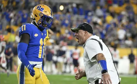  ?? Associated Press ?? Pittsburgh head coach Pat Narduzzi celebrates a safety with linebacker Bangally Kamara (11) during the second half Nov. 5 against Syracuse at Acrisure Stadium.