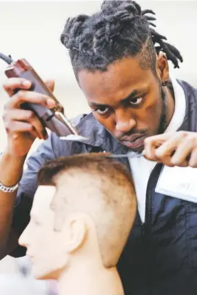  ?? STAFF PHOTOS BY ERIN O. SMITH ?? Brandon Long, a Tennessee College of Applied Technology-Paris student, participat­es in the barbering competitio­n during the Tennessee State Leadership and Skills Conference at the Chattanoog­a Convention Center on Tuesday.