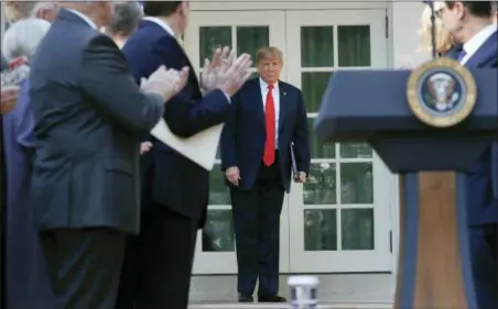  ?? PABLO MARTINEZ MONSIVAIS — THE ASSOCIATED PRESS ?? President Donald Trump is applauded as he walks out of the Oval Office to announce a revamped North American free trade deal, in the Rose Garden of the White House in Washington, Monday. The new deal, reached just before a midnight deadline imposed by the U.S., will be called the United States-Mexico-Canada Agreement, or USMCA. It replaces the 24-year-old North American Free Trade Agreement, which President Donald Trump had called a job-killing disaster.