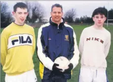  ??  ?? Claude Mannas, Wimbledon FC’s chief scout in Ireland, with local lads Shane Mullally and William O’Callaghan during trials in Doneraile.