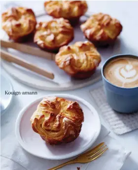  ??  ?? Kouign-amann KOUIGN-AMANN Dinner plate (back) from Thrown by Jo. Globe dish (front) from Batch Ceramics. Cup from Studio Enti.
STEPS Apron (worn throughout) and linen fabric (under wire rack and tray) from Stone. Stand mixer from KitchenAid. Oval...