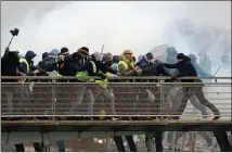  ??  ?? Police try to block Yellow Vests from crossing a Paris bridge.