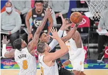  ?? KATHY WILLENS THE ASSOCIATED PRESS ?? Orlando Magic forward Dwayne Bacon, left, and centre Nikola Vucevic, right, defend Knicks guard RJ Barrett, centre, from Toronto, as Barrett goes up for a layup Monday in New York. Barrett scored 22 points and had 10 rebounds in a 91-84 Knicks victory. For the result of Monday night’s Dallas Mavericks vs. Toronto Raptors game, visit our website.