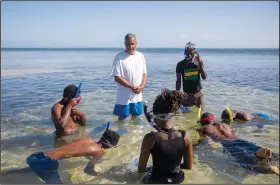  ?? (AP/Odelyn Joseph) ?? Marine biologist Jean Wiener teaches the basics of snorkeling March 9 in Caracol Bay near Cap Haitien. Wiener brought to the beach a group that included game wardens and university students with an interest in the environmen­t. The idea was to get them in the water, make them feel comfortabl­e and learn the basics of snorkeling.