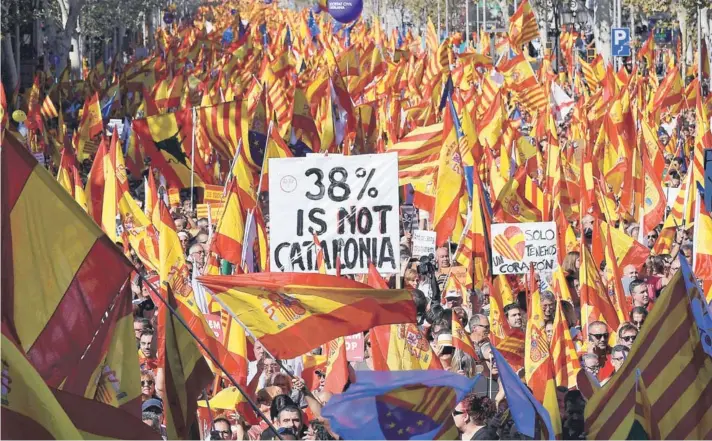 ??  ?? ► Manifestan­tes portan banderas españolas, catalanas y pancartas durante una manifestac­ión a favor del unionismo, ayer en Barcelona.