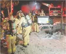  ?? BILL BELL, OTTAWA FIRE SERVICES ?? District 6 firefighte­rs worked in frigid temperatur­es while battling a blaze at a home near MacLaren's Landing on Thursday night.