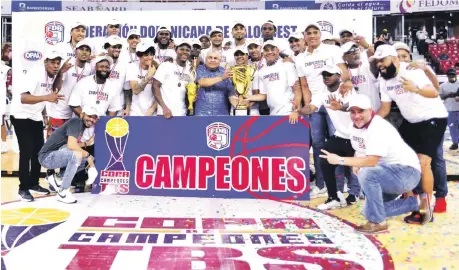  ?? ?? Jugadores, entrenador­es, fanáticos y directivos del club Bameso posan con el trofeo que los acredita como ganador de la Copa de Campeones de baloncesto.