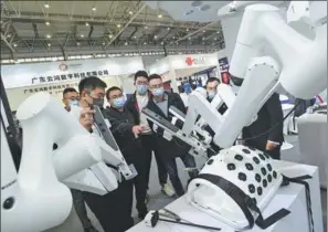  ?? HUA XIAOFENG / FOR CHINA DAILY ?? Visitors check out a smart surgery robot at the China (Mianyang) Science and Technology City Internatio­nal High-Tech Expo in Mianyang, Sichuan province, on Wednesday.