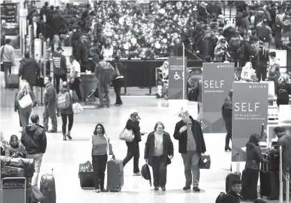  ?? Associated Press file ?? ABOVE: Passengers pass through Terminal A on Nov. 22 at Logan Internatio­nal Airport in Boston. It’s getting late for booking holiday travel, but not too late. Experts say there are tips for procrastin­ators to find affordable airfares and hotel rooms....