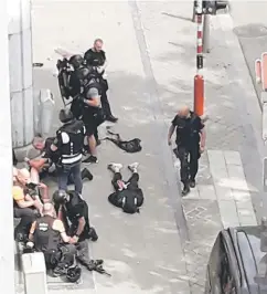  ??  ?? Police special forces are seen next to a man on the pavement, supposed to be the shooter, during a shooting in Liege, Belgium. — Reuters photo