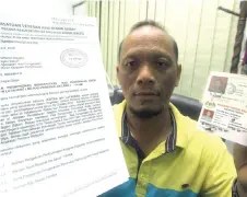  ??  ?? Justan, shows his Royal Malaysian Army veteran card and letter from PVATM Sabah at Bernama office. — Bernama photo