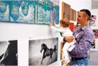  ??  ?? BABY TOUCH: Artist Dmytro Pavlenko Elizabeth shares a light moment with his daughter during the ongoing exhibition.