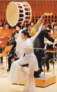  ?? — Photos/Ti Gong ?? Chen Yining playing the pipa behind the back, a typical dancing posture depicted on Dunhuang murals