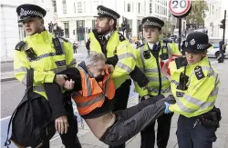  ?? Pictures: PETER MACDIARMID/ LNP; GETTY & HOWARD JONES / I-IMAGES ?? Ugly scenes at protest... police remove an Insulate Britain protester yesterday, left. A car is blocked as anger rises on the roads, right