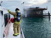  ?? CITY OF MIAMI FIRE RESCUE ?? A City of Miami Fire Rescue boat crew sprays water on a burning house at Stiltsvill­e on Monday.